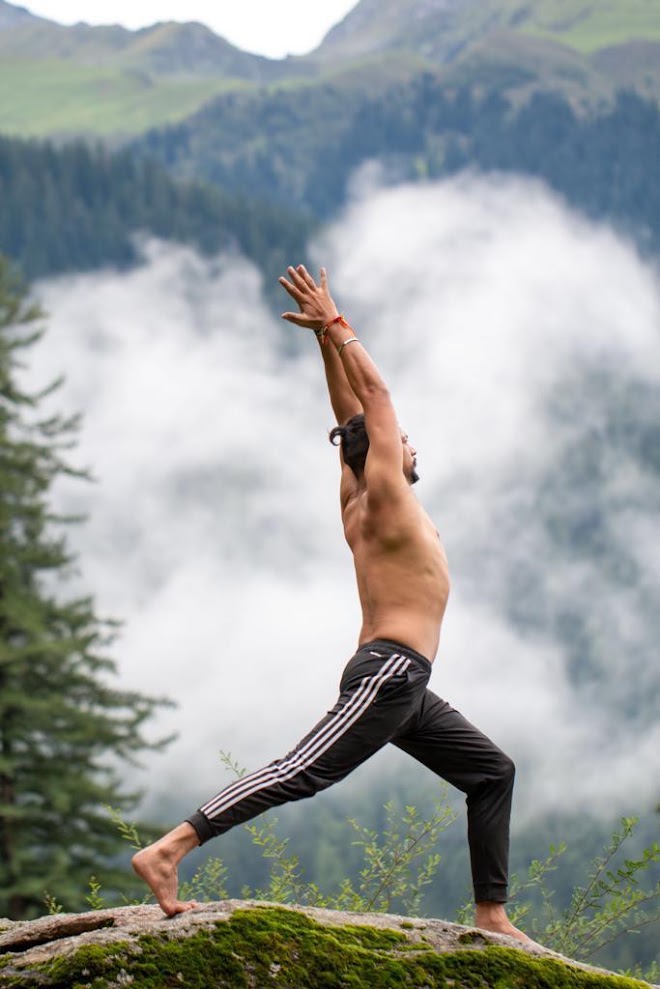 Arun Maan practicing yoga in a misty mountain landscape in India